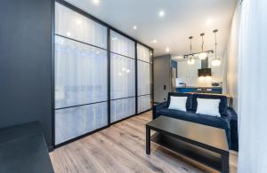 a living room with a blue couch and a large window at Modern loft style apartment in Kyiv