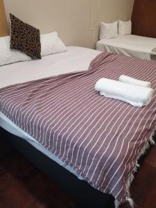 a bed with two towels on top of it at 180 On Anderson Guest House in Pretoria