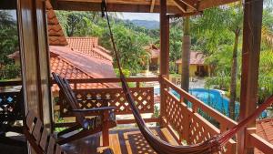 a hammock on the balcony of a house with a pool at Hotel Ritmo Tropical - Pool and Breakfast in Santa Teresa Beach