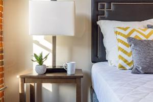 a bedroom with a table with a lamp and a bed at Riverfront Park Travel Apartments in Spokane