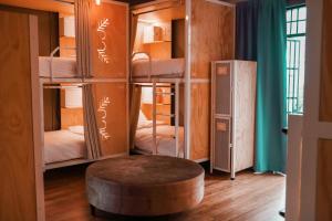 a room with bunk beds with a table and a stool at Casa Pepe Hostel Boutique - CDMX in Mexico City