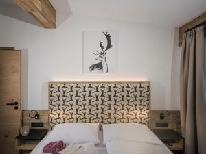 a bedroom with a bed with a headboard at LENZup Apartments in Mayrhofen