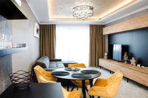 a living room with a table and chairs at Apartmány PRESTIGE Donovaly in Donovaly