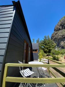 una casa nera con un tavolo e sedie su una terrazza di Geotermas Spa de Montaña ad Antuco