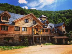 a large wooden house with a person in front of it at Apartment Midzor in Crni Vrh