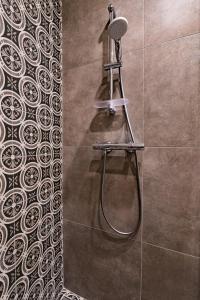 a shower with a hose in a bathroom with at Allegro in Liepāja
