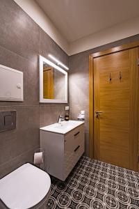 a bathroom with a toilet and a sink and a door at Allegro in Liepāja