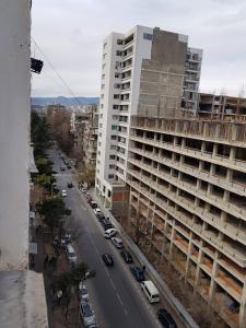 una calle de la ciudad con coches aparcados frente a un edificio alto en Hostel Levan, en Tiflis