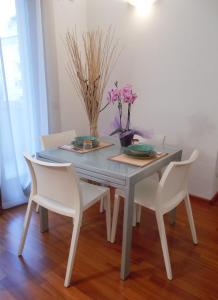 una mesa de comedor con 2 sillas y flores. en Residenza San Bortolo en Vicenza