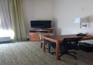 Cette chambre dispose d'un bureau, d'une télévision, d'une table et de chaises. dans l'établissement Candlewood Suites Temple, an IHG Hotel, à Temple