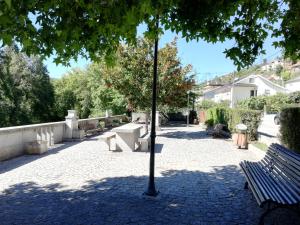 a park with a bench and a light pole at Casarão do Alva in Penalva de Alva