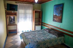 a bedroom with a bed and a green wall at Pousada Recanto da Chapada in Mucugê
