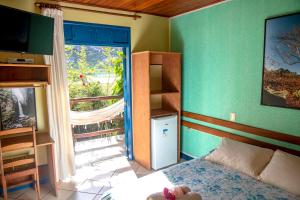 a bedroom with a bed and a window and a television at Pousada Recanto da Chapada in Mucugê