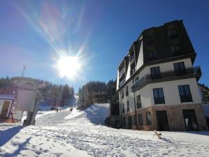 un edificio en una pista de esquí con el sol en el cielo en CENTRALA Jahorina en Jahorina