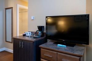 a hotel room with a large flat screen television at Irwin's Mountain Inn in Banff