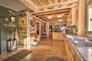Il comprend une grande cuisine avec des murs en bois et du parquet. dans l'établissement Sasquatch Inn Retreat Near Fishing and Hunting!, à Wise River