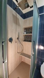 La salle de bains est pourvue d'une douche avec une porte en verre. dans l'établissement Appartamento Isabella - Residence Montesole, à Ponte di Legno