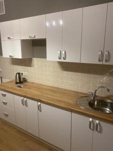 a kitchen with white cabinets and a sink at Ehostel360 in Ivano-Frankivsk