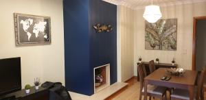 ヴィラ・ノヴァ・デ・ガイアにある3doorsDownの青い壁のリビングルーム(テーブル付)