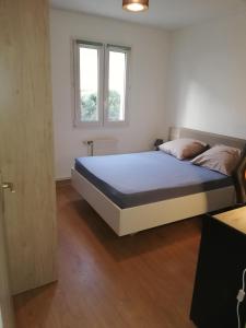 1 dormitorio con 1 cama en una habitación con ventana en Grand T3 avec clim, parking et terrasse privative - Agen, en Agen