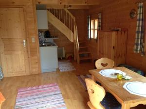 ein Esszimmer mit einem Holztisch und einer Küche in der Unterkunft Ferienhaus Beme in Spielberg
