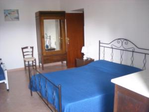 een slaapkamer met een blauw bed en een blauwe deken bij B&B Il Convento in Agropoli