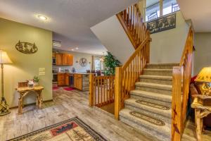 sala de estar con escalera y cocina en 3 Decks, Mtn Views! Tree Tops by HoneyBearCabins - Luxury Rain Showers, 3 King suites, XL HotTub, Bear Sightings en Gatlinburg