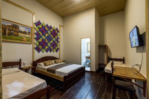 a room with two beds and a television in it at Reviver Hostel in São Luís
