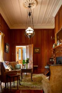 a living room with a couch and a chandelier at Karamana Homestead (1872) in Coromandel Town
