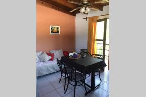 Un comedor con una mesa y sillas y una cama. en Departamento ALUMA, en San Rafael