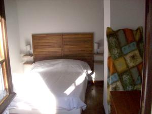 sypialnia z łóżkiem z drewnianym zagłówkiem w obiekcie Maison d'une chambre avec vue sur la ville jardin amenage et wifi a Puy l'Eveque w mieście Puy-lʼÉvêque
