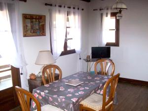 comedor con mesa, sillas y ventanas en Maison d'une chambre avec vue sur la ville jardin amenage et wifi a Puy l'Eveque en Puy-lʼÉvêque