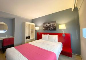 um quarto com uma cama grande e um cobertor rosa em Hotel MX forum buenavista em Cidade do México