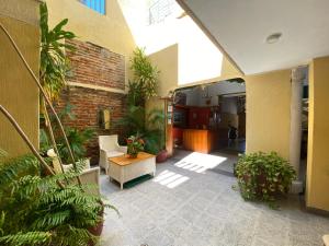 un cortile interno con piante e un muro di mattoni di Hotel Granate a Santa Marta