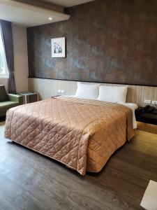 - une chambre avec un grand lit et une couverture brune dans l'établissement Aegean Garden Motel, à Wujie
