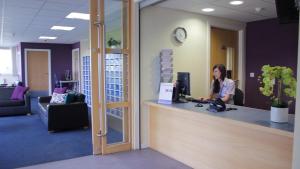 a woman sitting at a counter in an office at Queen Margaret University Residences in Musselburgh