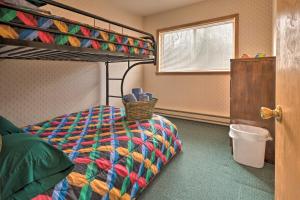 a bedroom with a bunk bed with a colorful comforter at Private Hot Tub and Fireplace Poconos Home! in Pleasant Mount