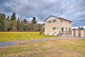 a large white house in a field with trees at Private Hot Tub and Fireplace Poconos Home! in Pleasant Mount