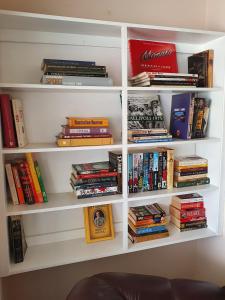 een boekenplank gevuld met veel boeken bij The Comfort Cottage on Williams in Broken Hill