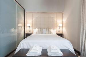 ミラノにあるミラン ロイヤル スイーツ セントロ カドルナのベッドルーム1室(白い大型ベッド1台、タオル2枚付)