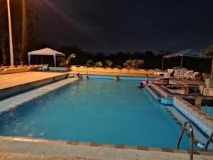 una piscina por la noche con gente en el agua en Hosteria Mar de Plata en Cabuyal