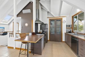 a kitchen with a refrigerator, stove, sink and a microwave at Seahaven Village in Barwon Heads