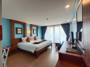 Dormitorio con cama, escritorio y TV en Saisawan Beach Resort, en Na Jomtien