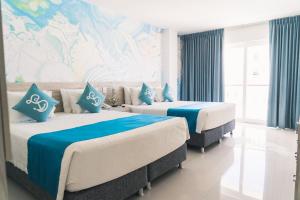 2 camas en una habitación de color azul y blanco en Sea Colors Hotel, en San Andrés