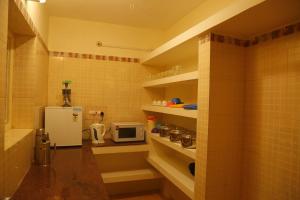 una pequeña cocina con nevera y microondas en Cliffhanger Retreat, en Yercaud