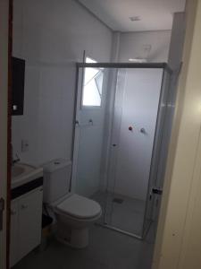 a bathroom with a shower with a toilet and a sink at Apartamento FLAT no centro - Passo de Torres SC in Pirataba
