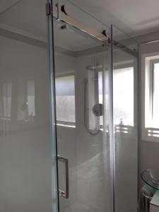 a shower with a glass door in a bathroom at Ironsands B&B in Patea