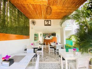 a restaurant with white tables and chairs and a wooden ceiling at Hotel Downtown Merida in Mérida