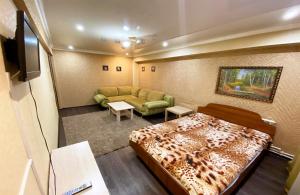ビイスクにあるApartment "Dobrie Sutki"on Merlina 20のベッド1台とソファが備わる小さな客室です。