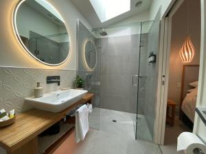 a bathroom with a sink and a shower at The Bay House Beachfront Accommodation in Cape Foulwind